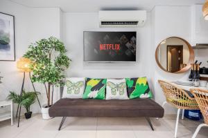 a living room with a couch and a mirror at Jungle Studio at Tambuli Ocean View by Dominik Studio with Pool & Balcony in Mactan in Lapu Lapu City