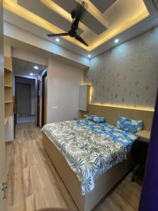a bedroom with a large bed with a ceiling fan at Infinity Haven in Greater Noida