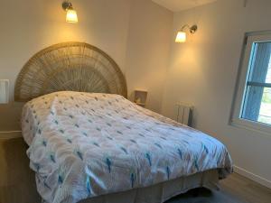 1 dormitorio con 1 cama grande y cabecero de mimbre en L'Hortensia, en Beuvron-en-Auge