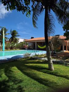 a house with a palm tree and a swimming pool at Sitio Damiana in Paracuru