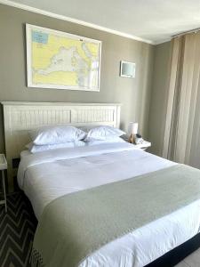 a bedroom with a large bed with a map on the wall at SaltySky Penthouse in Gansbaai