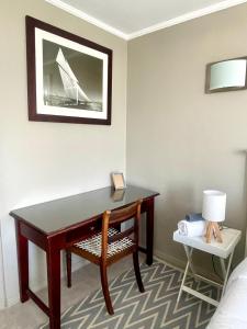 a desk in a hotel room with a lamp and a chair at SaltySky Penthouse in Gansbaai