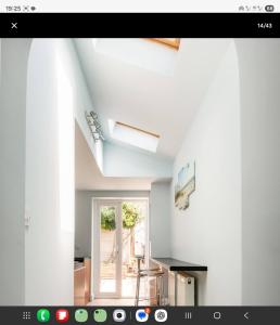 a room with white walls and a window and a kitchen at Central Beach Cottage - outside conservation area, minutes walk to all amenities in Deal