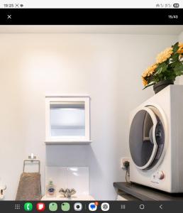 a kitchen with a microwave and a window at Central Beach Cottage - outside conservation area, minutes walk to all amenities in Deal