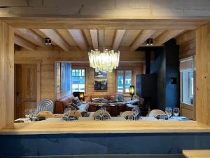 a living room with a chandelier and a table and chairs at -Les Clématites- Chalet Exclusif, Villars Centre in Villars-sur-Ollon