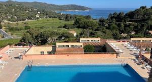 a large swimming pool with a view of the ocean at Gigaro Apt 4 pers Vue mer Plage a pieds Piscine Tennis in La Croix-Valmer
