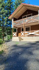 a log cabin with a porch and stairs to it at Гірська роса in Synevyrsʼka Polyana