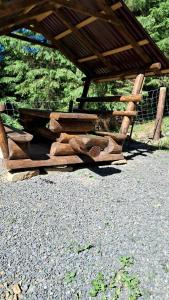 a wooden bench sitting under a wooden structure at Гірська роса in Synevyrsʼka Polyana