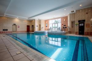 een groot zwembad met blauw water in een gebouw bij The Aberdeen Altens Hotel in Aberdeen