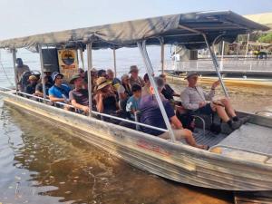 a group of people sitting in a boat on the water at Top Stay Inn in Kasane