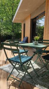 une table de pique-nique verte et des chaises sur une terrasse dans l'établissement Le Cormier lodge, entre Loire et Anjou, à La Chapelle-Saint-Florent