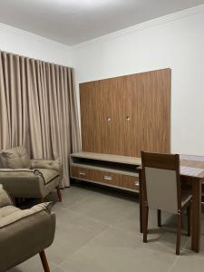 een woonkamer met een tafel, een stoel en een kast bij Edifício Catarina in Sorocaba