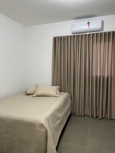 een slaapkamer met een bed en een raam met verwarming bij Edifício Catarina in Sorocaba