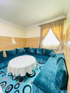 a living room with a blue couch and a white table at Cozy & Chic Agadir Netflix, Beach & Comfort in Agadir