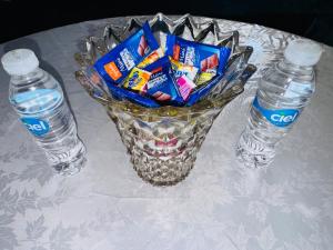 a table with a vase of candy and two water bottles at Cozy & Chic Agadir Netflix, Beach & Comfort in Agadir