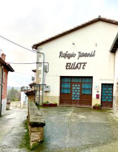 a building with a sign on the side of it at Albergue Urbasa in Eulate