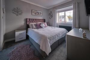 a bedroom with a bed and a window at Village Stay in The Heart of Torrance in Glasgow