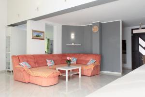 een oranje bank in een woonkamer met een tafel bij Villa Petra in Kastav