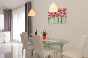 een eetkamer met een glazen tafel en witte stoelen bij Villa Petra in Kastav