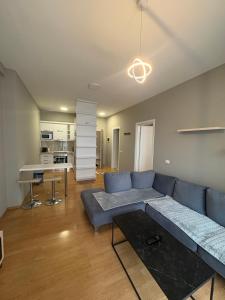 Una sala de estar con un sofá azul y una mesa. en K&M apartment, en Tirana