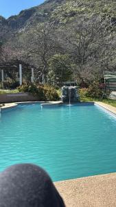 - une piscine avec une fontaine en face d'une montagne dans l'établissement Rest house in San José de Maipo, à San José de Maipo