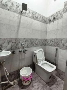 un baño con inodoro y lavabo en Rainbow Inn, en Varanasi
