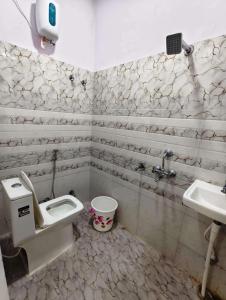 un baño con inodoro y lavabo en Rainbow Inn, en Varanasi