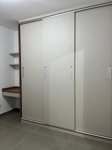 een grote kast met witte deuren in een kamer bij Edifício Catarina in Sorocaba