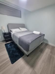 Un dormitorio con una cama y suelo de madera. en Kelvista's suite, en Winnipeg