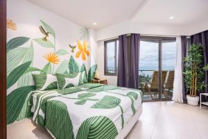 a bedroom with a green and white bed with a tropical mural at Jungle Studio at Tambuli Ocean View by Dominik Studio with Pool & Balcony in Mactan in Lapu Lapu City +38 photos