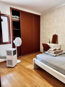 a bedroom with a bed and a desk and a fan at StayBaixa Faro in Faro