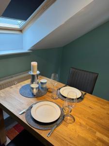 a wooden table with plates and wine glasses on it at Ferienwohnung in Gütersloh in Gütersloh