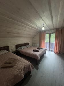 een slaapkamer met 2 bedden en een raam erin bij Гірська роса 2 in Synevyrsʼka Polyana