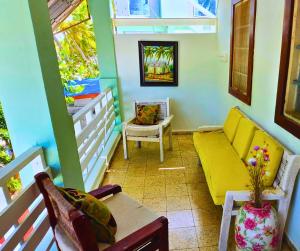 d'un salon avec un canapé et des fauteuils jaunes. dans l'établissement Sunbeha Resort, à Juan Dolio