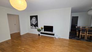 un salon avec une télévision à écran plat et une table dans l'établissement Bright 3-Bedroom Apartment with Balcony, à Göteborg