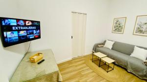 a living room with a couch and a flat screen tv at Villa Estrella in Dos Hermanas