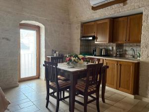 a kitchen with a table with flowers on it at Trullo La Visita Meravigliosa in Alberobello