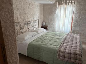 アルベロベッロにあるTrullo La Visita Meravigliosaのベッドルーム1室(ベッド1台、緑の掛け布団付)