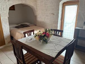 アルベロベッロにあるTrullo La Visita Meravigliosaの花瓶付きのダイニングテーブル