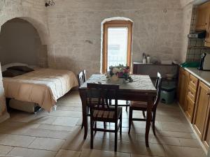 アルベロベッロにあるTrullo La Visita Meravigliosaのキッチン(テーブル、椅子、ベッド付)
