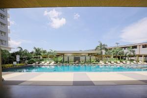 a large swimming pool with chairs and a building at The Studio Haven in Bacolod