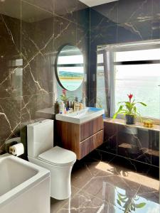 Un baño con inodoro, lavabo y espejo. en York House, en Exmouth