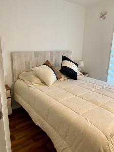 a bedroom with a bed with two pillows on it at Departamento en Pucón in Pucón