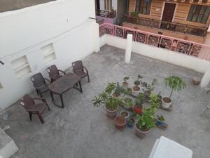 d'un balcon avec une table, des chaises et des plantes en pot. dans l'établissement Pink City Heritage Homestay, à Jaipur 6 autres photos