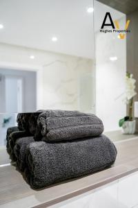 a row of grey towels sitting on a counter at Modern One-Bedroom Apartment - Central Location, Free Wi-Fi, 4 Mins from Station By AV Hughes Properties in Milton Keynes