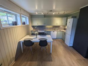 eine Küche mit einem weißen Tisch und Stühlen in der Unterkunft Apartment, Sea View, Terrace, Free Parking in Tromsø