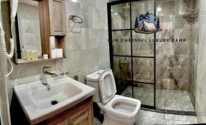 ワディ・ラムにあるWADI RUM CHEERFUL lUXURY CAMPの洗面台、トイレ、シャワー付きのバスルーム