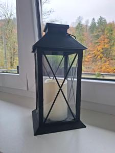 une lanterne noire posée devant une fenêtre dans l'établissement Ferienwohnung am Nissberg Grünau im Almtal, à Grünau im Almtal 36 autres photos