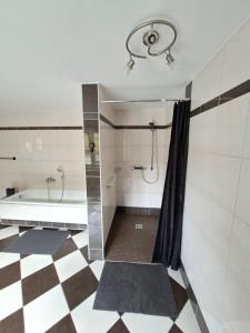 a bathroom with a tub and a shower with a shower curtain at Ferienwohnung am Nissberg Grünau im Almtal in Grünau im Almtal +34 photos