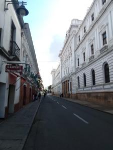 an empty street with white buildings on the side at Constitucional in Sucre
